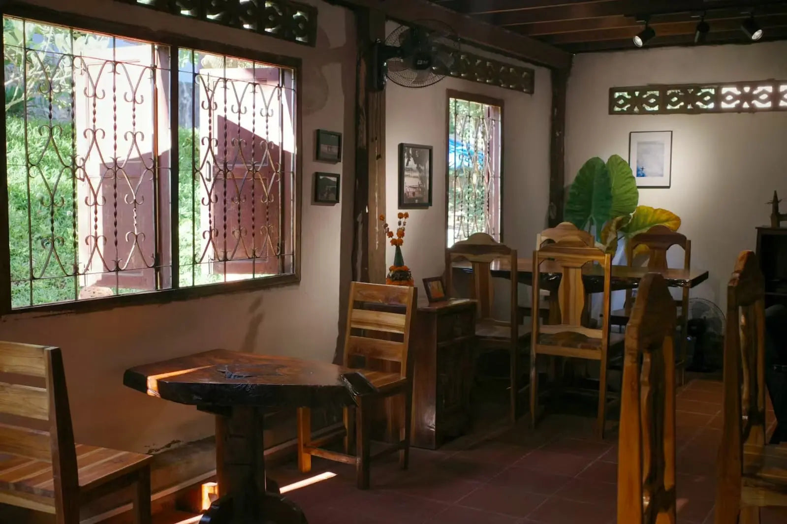 Xiangman Old House Café · Hiking Station Dining area with wooden furniture and decorative elements in a room with large windows.